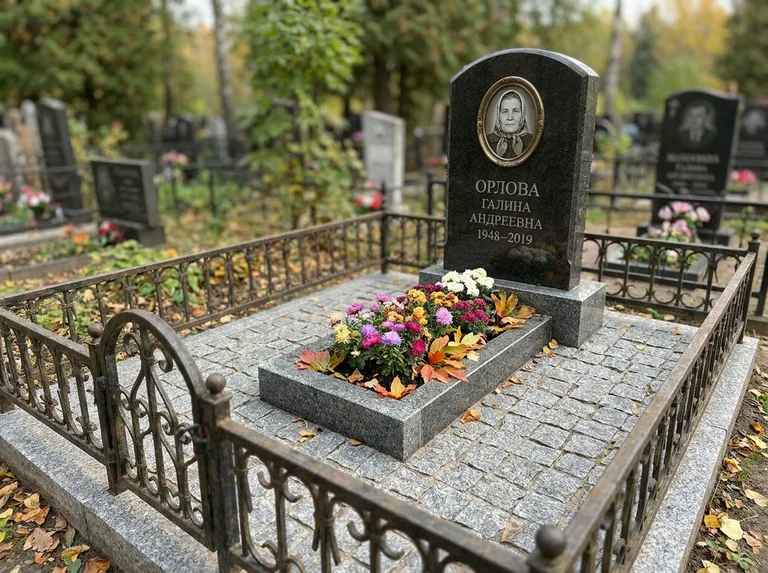 Благоустроенное захоронение с гранитной плиткой, оградой и цветником в Хабаровске