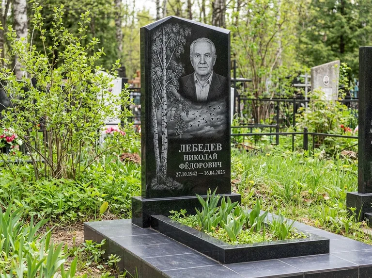 Памятник с гравировкой берёзы: вертикальная стела со скошенным верхом — берёза и стая птиц в небе, гранитный цоколь с тёмной плиткой, работа «Лебедев» в Хабаровске