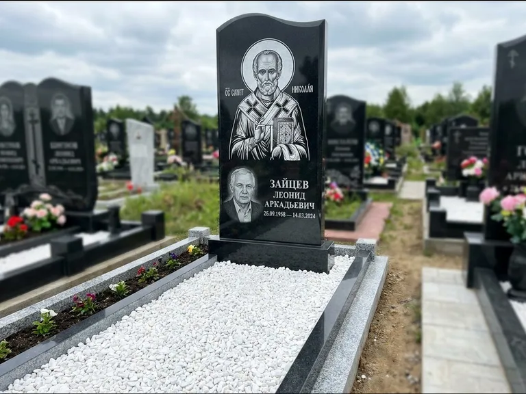 Памятник с гравировкой иконы: стела с крестообразным навершием — икона в резной рамке-киоте, газон без ограды, стриженая трава, работа «Раевская» в Хабаровске