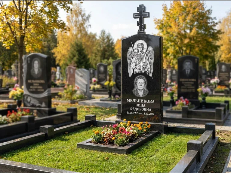 Памятник с гравировкой иконы: округлая стела-медальон с ликом — гравировка Богородицы «Семистрельная», луговые травы и полевые цветы за участком, работа «Гущин» в Хабаровске