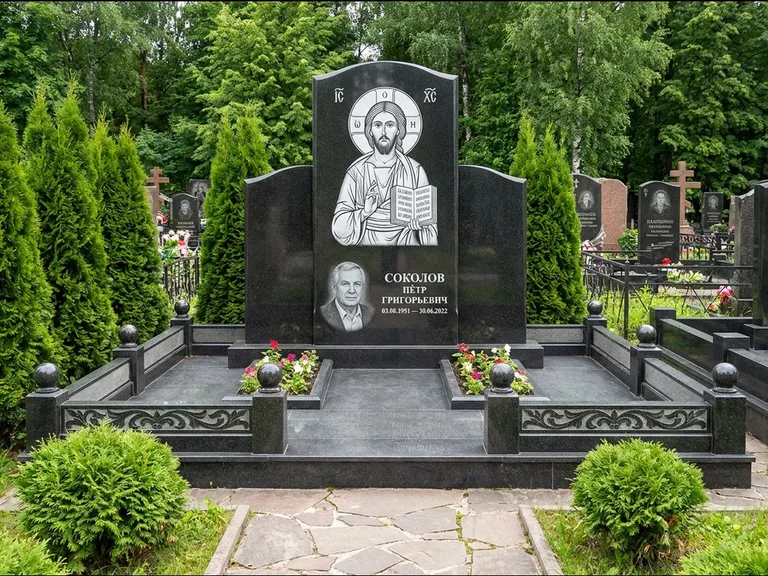 Памятник с гравировкой иконы: широкая горизонтальная лежачая плита-стела — икона в резной рамке-киоте, серая гравийная отсыпка с бордюром, работа «Богданова» в Хабаровске