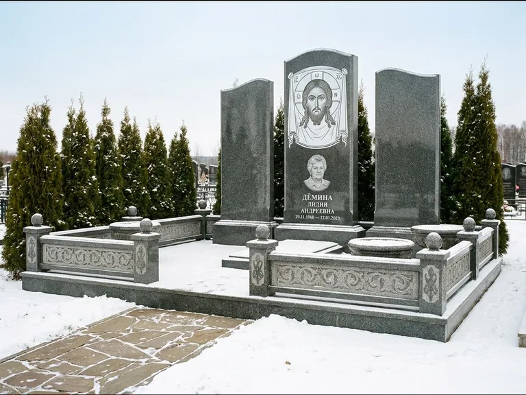 Памятник с гравировкой иконы: узкая вертикальная стела-пилон с ликом — икона в резной рамке-киоте, открытая лужайка без ограды, работа «Одинцов» в Хабаровске