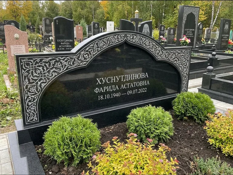 Мусульманский памятник: вытянутая горизонтальная семейная стела с аркой — белая гравировка силуэта мечети с минаретами, участок с декоративными кустами, работа «Зарипова» в Хабаровске
