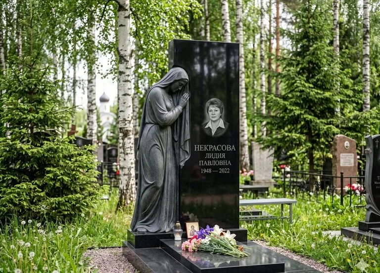 Гранитная фигура скорбящего мужчины у чёрной стелы в Хабаровске
